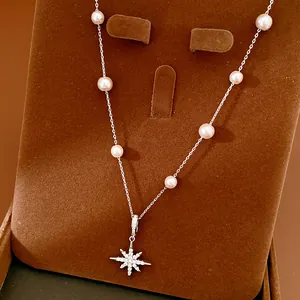 Close-up of the elegant zircon star pendant and white pearls on a silver-toned necklace