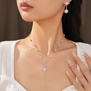 Elegant starburst pearl necklace and earring jewelry set worn by a stylish model.