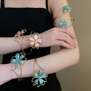 Close-up van elegante armbanden met roze en blauwe emaille bloemen op de arm