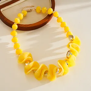 Vue détaillée d'un collier ras du cou en acrylique jaune avec de grosses perles