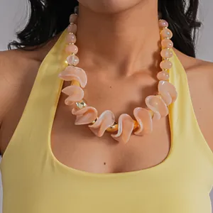 Collier tendance en acrylique avec perles irrégulières pêche porté par un mannequin