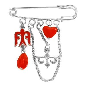 Vista macro detallada de un broche de estilo kazajo con dijes de esmalte rojo y cadenas