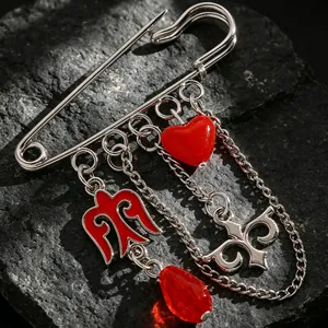 Primer plano de un broche de plata de estilo kazajo con corazón rojo y adornos