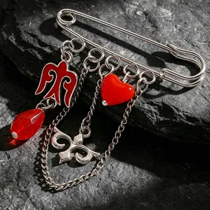 Primer plano de un broche kazajo con colgantes de esmalte rojo y cuentas de corazón