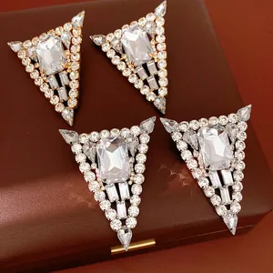 Detail of silver needle triangle earrings with sparkling rectangular and teardrop crystals