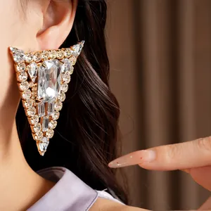 Close-up of oversized triangular crystal earring with sparkling rhinestone detail