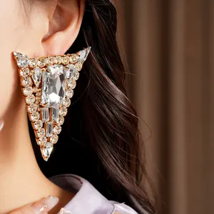 Close-up detail of luxury oversized triangle rhinestone stud earrings with silver needle