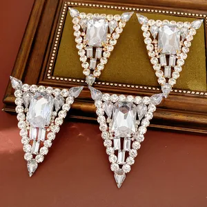 Close-up detail of silver needle triangular earrings with luxury sparkling rhinestones