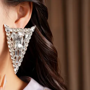 Detailed macro view of an exaggerated triangular crystal earring on a model's ear