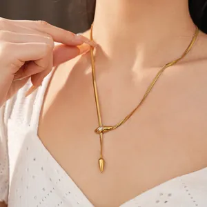 Gros plan d'un mannequin portant un collier serpent en acier doré avec cristal
