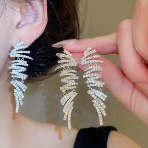 Detail view of 18k gold plated geometric drop earrings with sparkling zircon stones