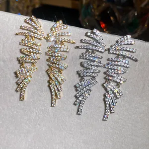 Close-up of geometric wing-shaped earrings featuring shimmering cubic zirconia stones