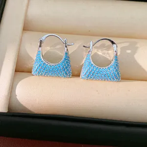Close-up of vintage blue stone pavé trapezoid hoop earrings displayed in a jewelry box