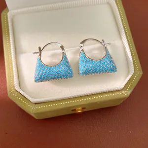 Close-up of elegant blue turquoise handbag-shaped hoop earrings in a gift box