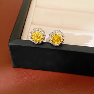 Elegant round yellow zircon stud earrings set in a decorative silver-tone flower frame