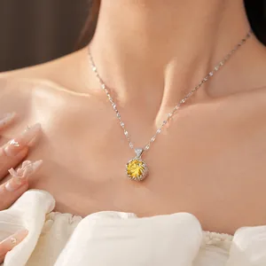 Detail of an elegant silver necklace with a brilliant yellow zircon pendant on a model.