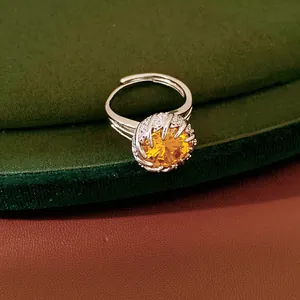 Macro view of a luxury yellow faceted zircon open ring resting on green velvet fabric