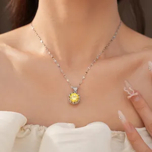 Close-up view of a minimalist necklace featuring a round yellow zircon pendant on a model
