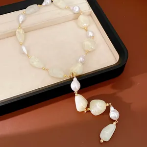 Detailed view of an irregular geometric acrylic pearl necklace with golden metal links