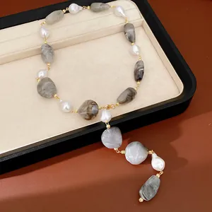 Detailed view of irregular grey marble acrylic and pearl necklace with gold links