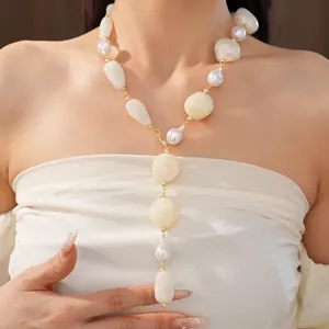 Detailed view of an irregular geometric acrylic pearl necklace worn by a female model