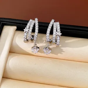 Dettaglio di eleganti orecchini a lobo a tre strati con stelle in zircone argento.