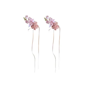 Pair of purple lily of the valley floral hair clips with elegant ribbons and tassels.