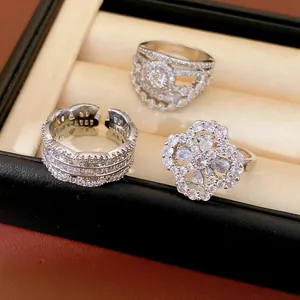 Detail view of three silver-tone rings with cubic zirconia in a velvet jewelry box.