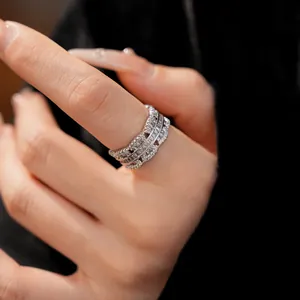 Macro detail of a silver-toned open ring featuring clear cubic zirconia on a hand.