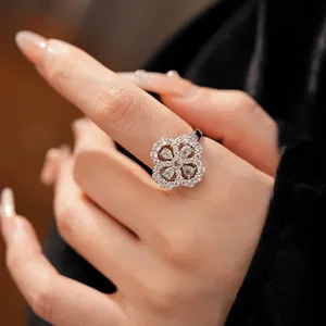 Detailed view of an elegant sparkling zircon flower ring with pear-shaped stones on finger