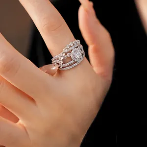 Detailed macro shot of an intricate silver ring with sparkling zirconia stones on a hand.