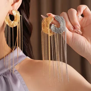Large irregular gold and silver tassel earrings on model