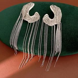 Statement irregular silver tassel earrings on green velvet display stand