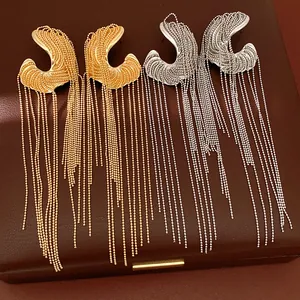 Close-up view of irregular long metallic fringe tassel earrings in gold and silver tones.