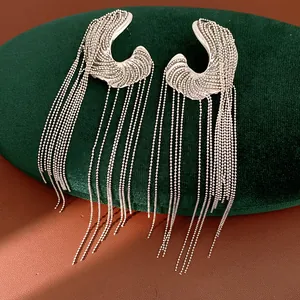 Macro detail view of silver long fringe earrings with irregular metallic texture