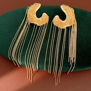 Macro view of golden irregular long tassel earrings featuring delicate bead chains