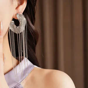 Close-up detail of silver long tassel earrings with irregular design worn by a model