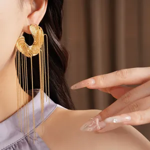 Detailed view of irregular long tassel earrings in gold finish with delicate beaded chains