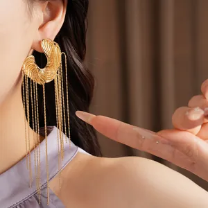 Detailed view of irregular golden tassel earrings with long metallic bead chains