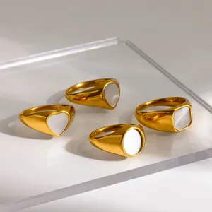 Goldene Edelstahlringe mit Herz und geometrischen Einlagen aus weißer Muschel.