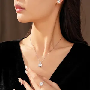 Elegante set di gioielli con zirconi quadrati: collana, orecchini e anello su modella.
