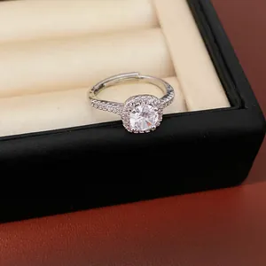 Dettaglio macro di un anello halo in argento con zirconia tonda e pavé scintillante
