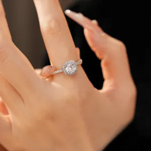 Primo piano dettagliato di un elegante anello halo con zircone indossato al dito
