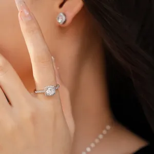 Dettaglio di un elegante anello halo in zirconia cubica con orecchini abbinati su modella