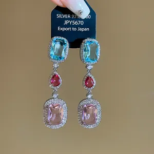 Detailed view of three-tier multi-colored zircon drop earrings on silver setting