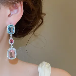 Close-up view of elegant silver-needle zircon drop earrings with colorful crystal stones