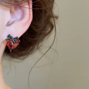 Detailed view of vintage red heart stud earrings featuring a sparkling black zircon bow