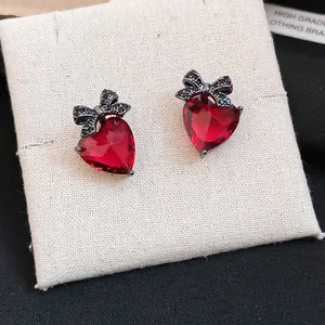 Close-up detail of vintage red heart zircon earrings with elegant black crystal bows