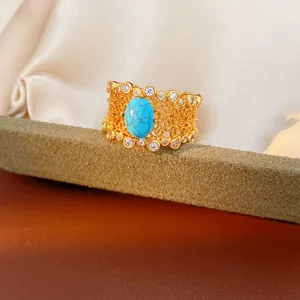 Macro view of an elegant gold-plated vintage ring with floral openwork and blue turquoise stone
