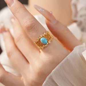 Detailed view of a vintage gold-plated hollow ring featuring a turquoise stone and zircons